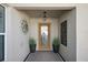 A stylish entryway featuring a decorative front door, hanging light fixture, and potted greenery at 1986 Altamonte Way, The Villages, FL 32162