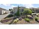 A front yard featuring professional landscaping with rocks, trees, and greenery at 1986 Altamonte Way, The Villages, FL 32162