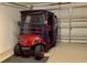 Garage containing a personal golf cart, with an automatic garage door on the right at 1986 Altamonte Way, The Villages, FL 32162