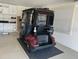 Enclosed golf cart parked inside of a garage with storage cabinets along the back wall at 1986 Altamonte Way, The Villages, FL 32162