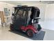 Enclosed golf cart parked inside of a garage with white walls and concrete flooring at 1986 Altamonte Way, The Villages, FL 32162