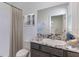 Well-lit bathroom with a granite countertop vanity, shower with curtain, and neutral finishes at 3071 Canopy Oak Blvd, Wildwood, FL 34785