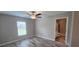 Bright bedroom featuring wood flooring, a ceiling fan, and an en-suite bathroom at 3326 Sw 128Th Street Rd, Ocala, FL 34473