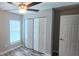 This bedroom has a ceiling fan, a closet with folding doors, and a window at 3326 Sw 128Th Street Rd, Ocala, FL 34473