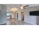 Spacious living area featuring wood floors, a ceiling fan, and a seamless flow into the modern kitchen at 3326 Sw 128Th Street Rd, Ocala, FL 34473