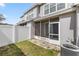 Backyard view featuring an enclosed patio area, a small patch of grass, and white vinyl fencing at 4491 Sw 49Th Ave, Ocala, FL 34474