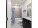 Cozy bathroom showcasing a shower-tub combo and dark vanity with grey countertop at 5370 Sw 45Th Ave, Ocala, FL 34474