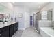 This well-lit bathroom has granite counters, double sinks, framed mirrors, and a glass-doored shower next to a tub at 5370 Sw 45Th Ave, Ocala, FL 34474