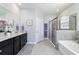 Elegant bathroom featuring granite countertops, dual sinks, a soaking tub, and a glass-enclosed shower at 5370 Sw 45Th Ave, Ocala, FL 34474