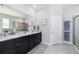 This modern bathroom features granite counters, double sinks, framed mirrors, and a glass-doored shower at 5370 Sw 45Th Ave, Ocala, FL 34474