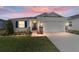 Well-lit home exterior with a two-car garage, stone accents and charming landscaping at 5370 Sw 45Th Ave, Ocala, FL 34474