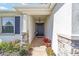 Inviting front entrance with stone accents, decorative plants, and a stylish black front door at 5370 Sw 45Th Ave, Ocala, FL 34474