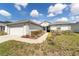 Exterior showcasing a home with a two-car garage, tidy landscaping, and welcoming walkway at 6213 Sw 97Th St, Ocala, FL 34476