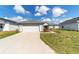 Exterior shot showcasing a two-car garage with a concrete driveway and landscaped front yard at 6213 Sw 97Th St, Ocala, FL 34476