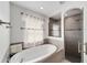 Serene main bathroom featuring a soaking tub and glass-enclosed shower with sleek gray tiling at 6213 Sw 97Th St, Ocala, FL 34476