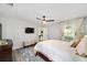 Airy main bedroom with white bedding, a ceiling fan, and large windows offering plenty of natural light at 6213 Sw 97Th St, Ocala, FL 34476