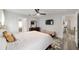 Bright bedroom with gray floors, white walls, a ceiling fan, and a glimpse into the en-suite bathroom at 6213 Sw 97Th St, Ocala, FL 34476