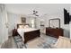 Comfortable bedroom with a wooden bed frame, dresser, ceiling fan, and a blue and white patterned rug at 6213 Sw 97Th St, Ocala, FL 34476