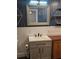 Bathroom with blue accent wall, vanity, and geometric mirror at 6699 Nw 61St St, Ocala, FL 34482