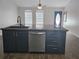 Kitchen island with dark cabinetry, stainless steel dishwasher, and a modern faucet at 6699 Nw 61St St, Ocala, FL 34482