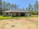 Back exterior view of house, showcasing a cozy porch area and nice lawn at 8303 Sw 127 Ave, Dunnellon, FL 34432