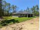 Back exterior view of house, showcasing a cozy porch area and beautiful new lawn at 8303 Sw 127 Ave, Dunnellon, FL 34432