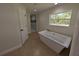 Bathroom with a soaking tub, a separate glass-enclosed shower, and a large window with a view at 8303 Sw 127 Ave, Dunnellon, FL 34432