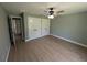 Bright bedroom featuring hardwood floors, ceiling fan, and double door closets at 8303 Sw 127 Ave, Dunnellon, FL 34432