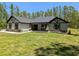 Charming single-story home featuring stone accents, timber details, and a well-manicured lawn in a wooded setting at 8303 Sw 127 Ave, Dunnellon, FL 34432