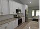 Modern kitchen featuring white cabinetry, stainless steel appliances, and granite countertops at 8303 Sw 127 Ave, Dunnellon, FL 34432