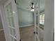 Bright living room with hardwood floors, ceiling fan, and natural light pouring in from large windows at 8303 Sw 127 Ave, Dunnellon, FL 34432