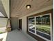 Inviting covered porch with wood ceiling detail and a view of the landscaped yard at 8303 Sw 127 Ave, Dunnellon, FL 34432