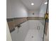Modern shower with white tile, decorative accents, and a glass enclosure with gold fixtures at 8303 Sw 127 Ave, Dunnellon, FL 34432