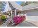Charming home featuring a well-manicured yard with vibrant azaleas and a welcoming front porch at 8475 Sw 91St Pl # E, Ocala, FL 34481