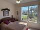 Bedroom featuring a large window with plantation shutters and views of the yard and neighborhood at 8504 Sw 84Th Loop, Ocala, FL 34481