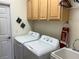 Well-equipped laundry room with modern washer and dryer units, plus ample cabinet space for storage at 8504 Sw 84Th Loop, Ocala, FL 34481