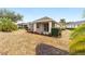 Rear view of home exterior with covered lanai, landscaping, shrubbery, and palm trees at 8669 Sw 88Th Loop, Ocala, FL 34481