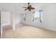 Light-filled bedroom with neutral carpeting, ceiling fan, and windows adorned with blue curtains at 8669 Sw 88Th Loop, Ocala, FL 34481