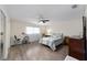 Bright bedroom with ceiling fan, hardwood floors and comfortable seating at 8677 Sw 95Th Ln # E, Ocala, FL 34481