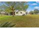 Lush backyard with a well-kept lawn, mature trees, and a screened-in porch for enjoying the outdoors in comfort at 8973 Sw 104Th Pl, Ocala, FL 34481