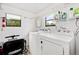 Bright laundry room featuring a washer, dryer, storage, and a window bringing in natural light at 8973 Sw 104Th Pl, Ocala, FL 34481