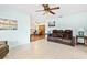 Bright living room featuring tile floors, a ceiling fan, and a comfortable brown reclining sofa at 8973 Sw 104Th Pl, Ocala, FL 34481