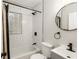 Updated bathroom featuring black fixtures, a shower with subway tile, and a glass block window at 903 Ne 2Nd St, Ocala, FL 34470