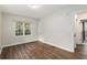 Bedroom with wood-look floors, a window, and a doorway to another room at 903 Ne 2Nd St, Ocala, FL 34470