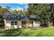 Inviting yellow home with a well-manicured lawn, mature trees, and an attached one car garage at 903 Ne 2Nd St, Ocala, FL 34470