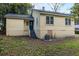 Exterior view of a quaint yellow home with a dark roof and a yard at 903 Ne 2Nd St, Ocala, FL 34470