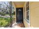 Welcoming black front door with decorative window and 'WELCOME' mat on the charming tiled porch at 903 Ne 2Nd St, Ocala, FL 34470