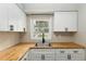 Kitchen with wooden countertops, stainless steel sink, and white cabinets at 903 Ne 2Nd St, Ocala, FL 34470