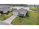 Aerial view of a well-maintained home with a spacious yard, a two-car garage, and serene pond views at 9238 Sw 60Th Terrace Rd, Ocala, FL 34476