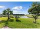 Lush backyard featuring a serene lake view, mature trees, and manicured lawn at 9238 Sw 60Th Terrace Rd, Ocala, FL 34476